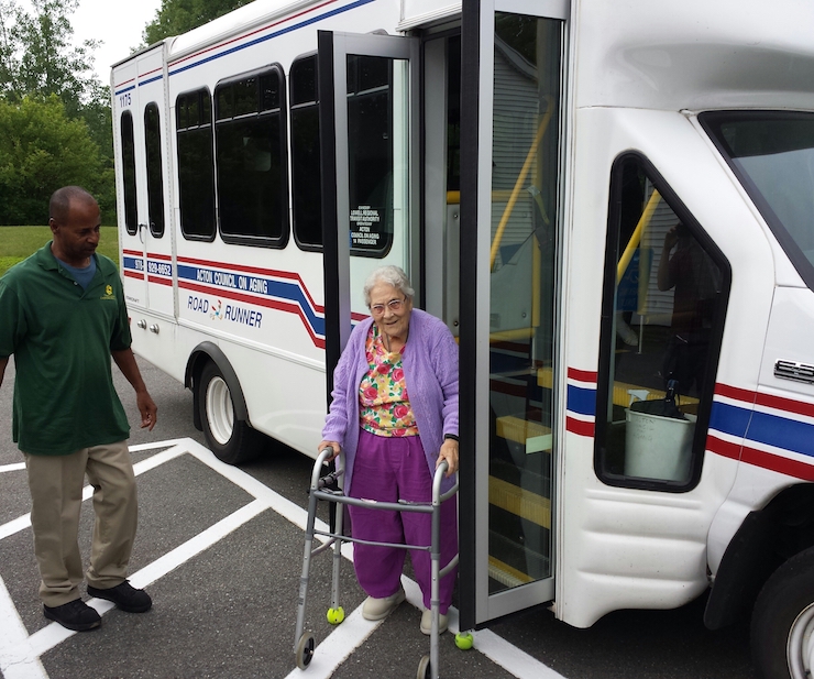 Older adult with walker stepping off of bus