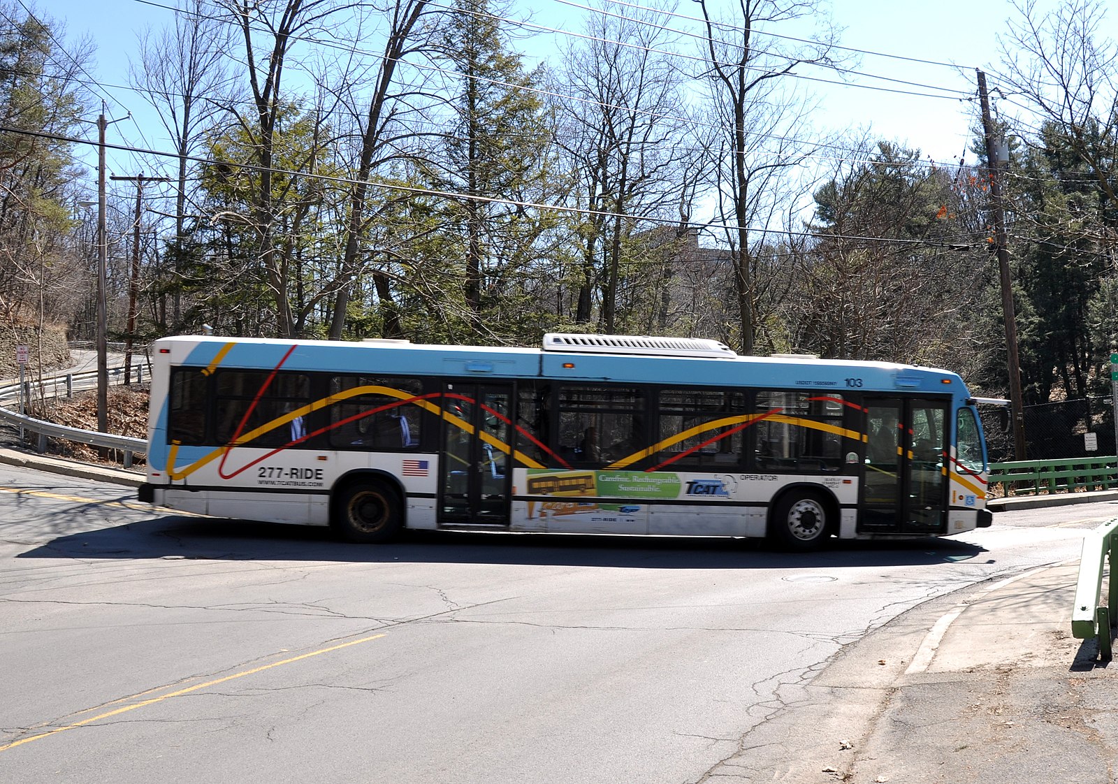 A bus turns left onto a narrow bridge.